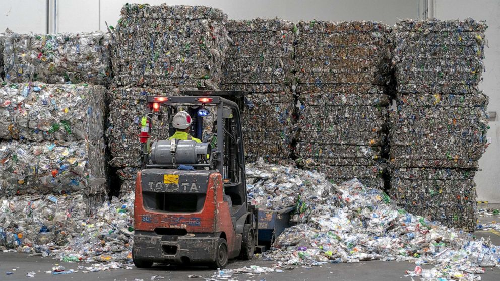 PHOTO: In this June 22, 2022, file photo, an employee operates a forklift to move bales of plastic bottles at the rPlanet Earth plastics recycling plant in Vernon, Calif.