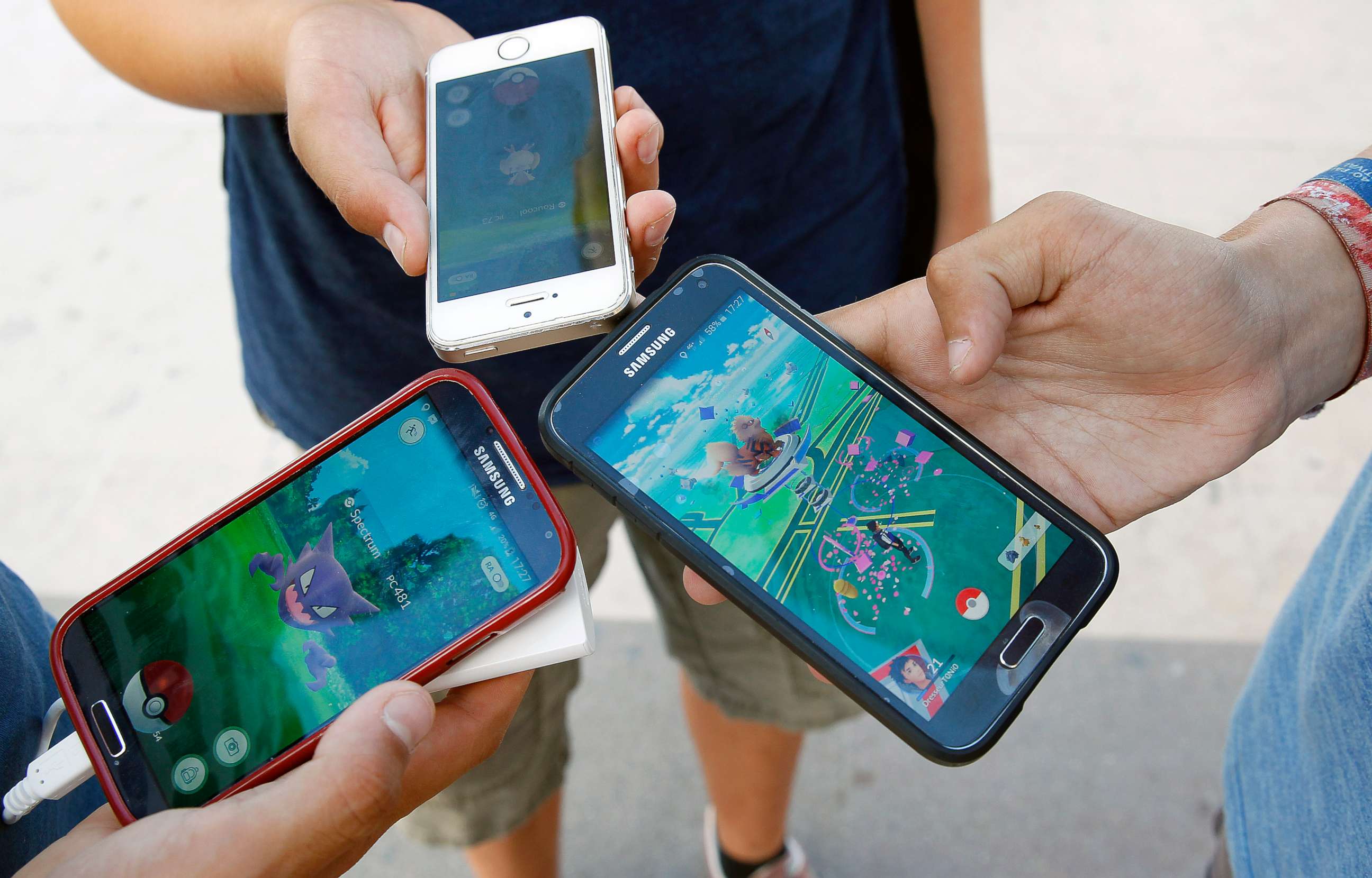 PHOTO: Kids show the screen of their smartphone with Nintendo Co.'s Pokemon Go augmented-reality game at the Trocadero in front of the Eiffel tower on September 8, 2016 in Paris, France.