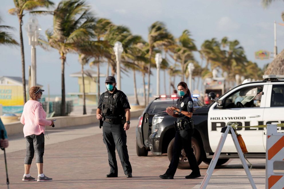PHOTO: Hollywood police officers monitor activity along the Hollywood Beach Broadwalk during the new coronavirus pandemic, May 13, 2020, in Florida.