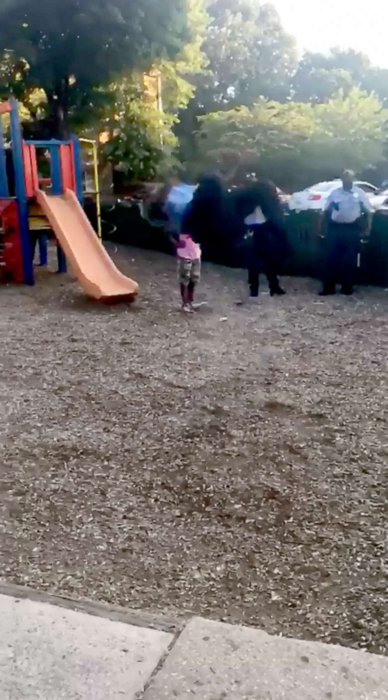 PHOTO: Officer Arthur Brown Jr. of DC Metropolitan Police performs a backflip on a playground in full uniform