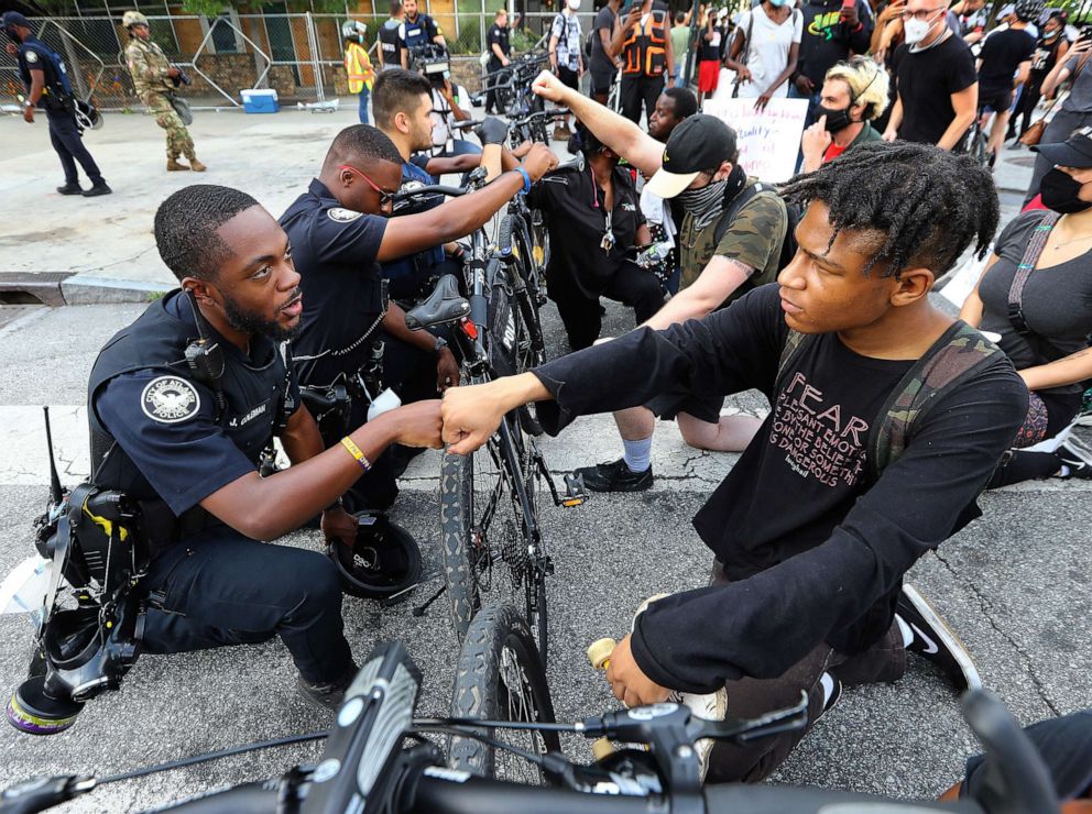 PHOTO: Atlanta Police Officer J. Coleman and protester Elijah Raffington fist bump in a symbolic gesture of solidarity outside the CNN Center at Olympic Park, in Atlanta, June 3, 2020.