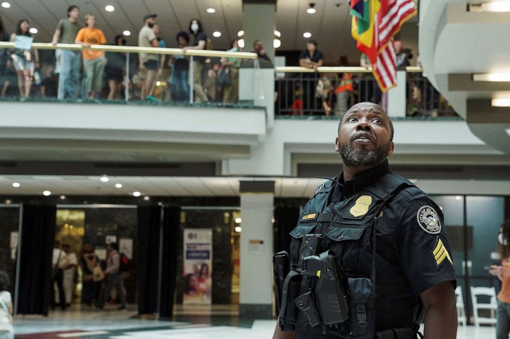 PHOTO: FILE - A police officer looks up as people protest against the controversial "Cop City" project, inside the city hall in Atlanta, May 15, 2023.