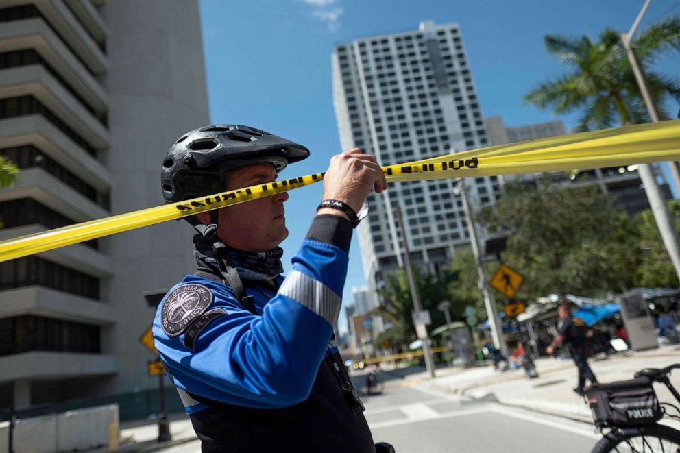 PHOTO: A Miami Police Officer lifts up police tape outside of the Wilkie D. Ferguson Jr. United States Federal Courthouse in Miami, June 13, 2023.