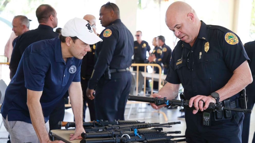 PHOTO: City of Miami Commissioner Ken Russell and City of Miami Police Officer Laurenceau look at some of the returned guns during a City of Miami gun buy-back event in Miami, March 17, 2018.