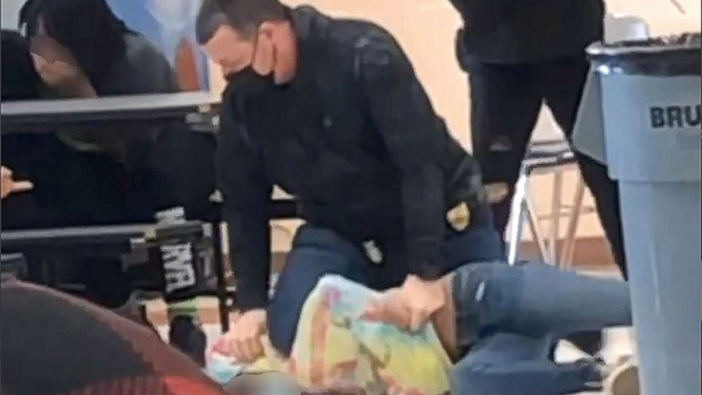 PHOTO: An off-duty police officer responds to a fight between two students at Lincoln Middle School in Kenosha, Wis., on March 4, 2022, in a still image from video. The officer appeared to kneel on the neck of a student, prompting an investigation.