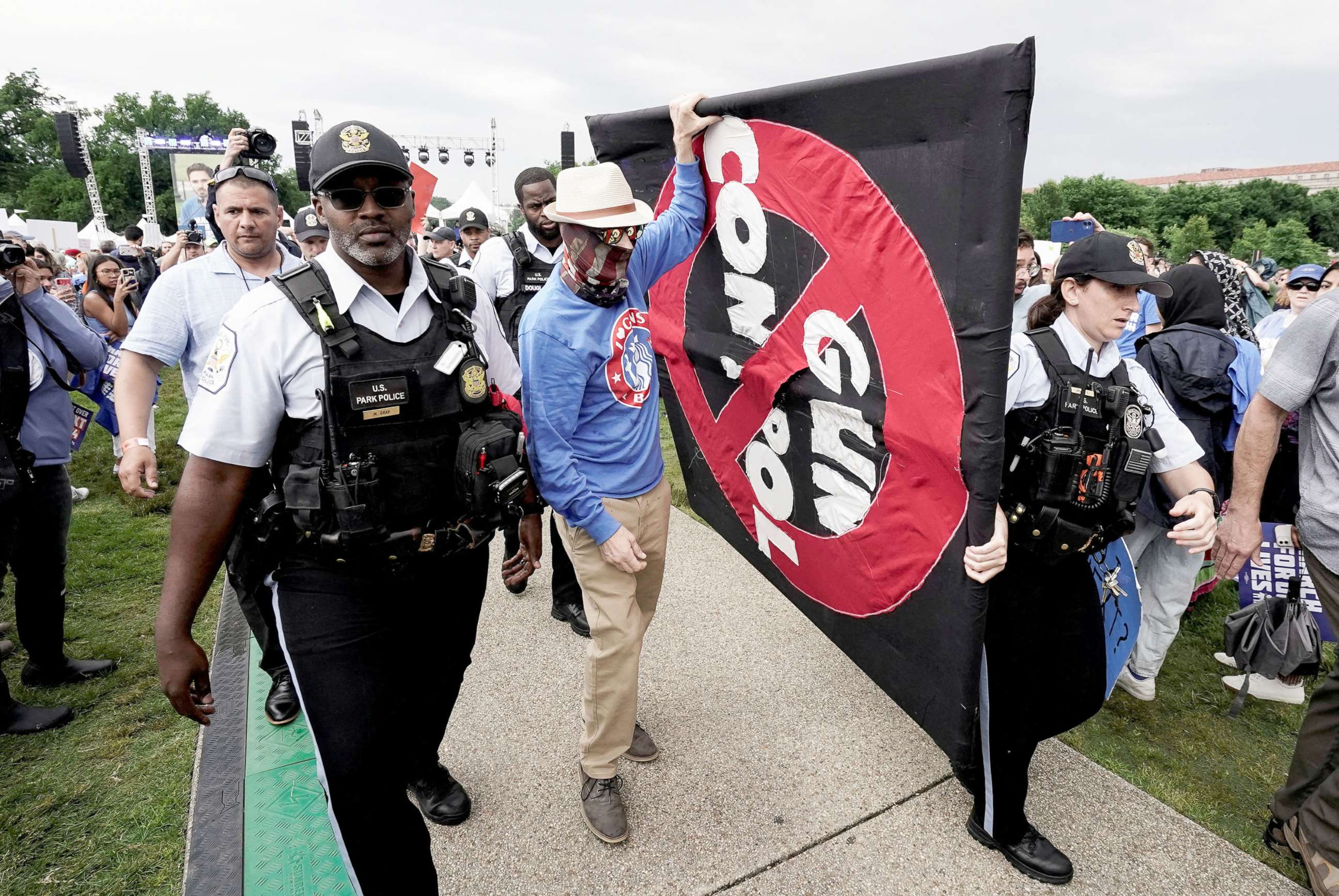 PHOTO: Police officers escort a pro-gun rights counter protestor carrying a poster through the crowd during the 'March for Our Lives', one of a series of nationwide protests against gun violence, in Washington, D.C., June 11, 2022. 