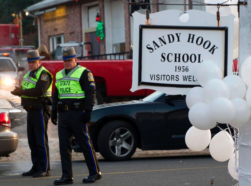 PHOTO: Police stand guard at the entrance after a mass shooting at the Sandy Hook School in Newtown, Conn., Dec. 15, 2012.