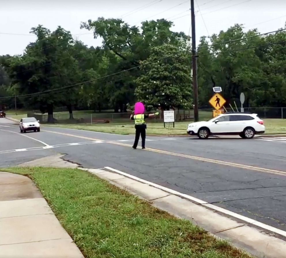 PHOTO: Woodstock Police officer Shane Bonebrake donned a purple wig on while directing school traffic after losing a bet with a 5th grader. 