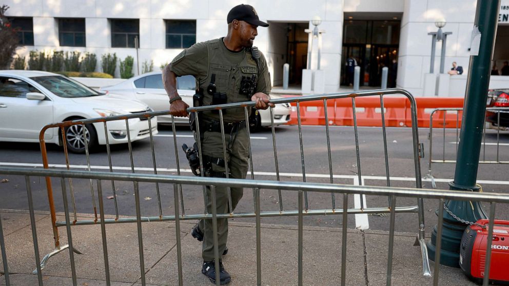 PHOTO: A Fulton County Sheriff officer rearranges fencing around the Fulton County Courthouse, Aug. 14, 2023 in Atlanta.