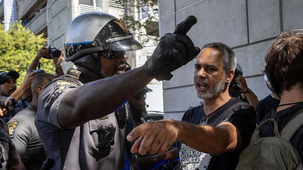 PHOTO: A police officer and a protester argue as protesters of "Cop City" approach the Lewis R. Slaton Courthouse ahead of an expected indictment of former President Donald Trump in Atlanta, Aug. 14, 2023.