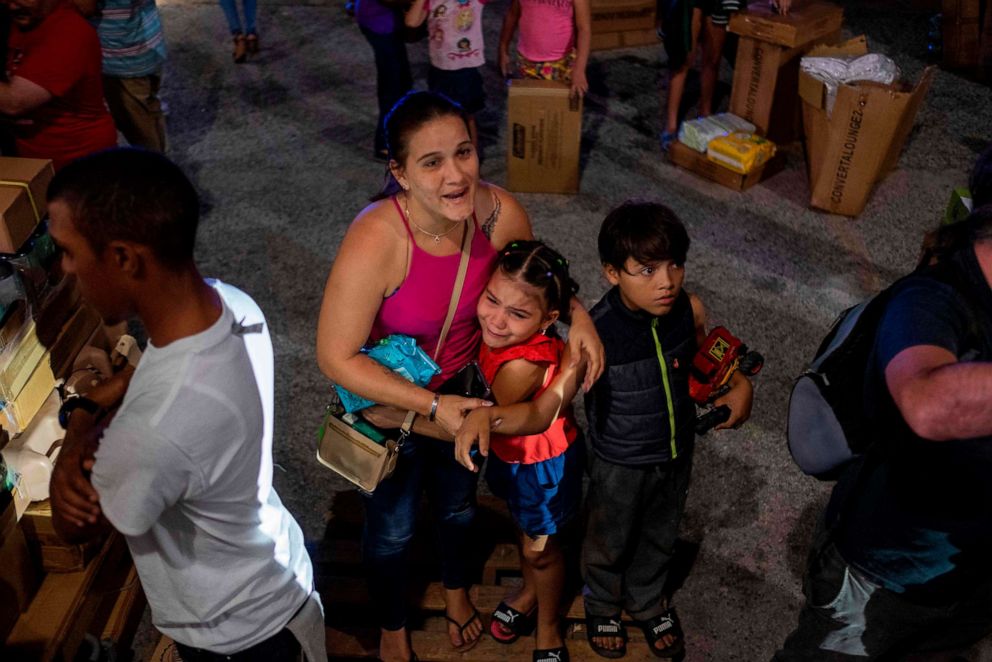 PHOTO: A girl cries next to her mother after police evacuated people breaking into a warehouse filled with supplies in Ponce, Puerto Rico on Jan. 18, 2020.