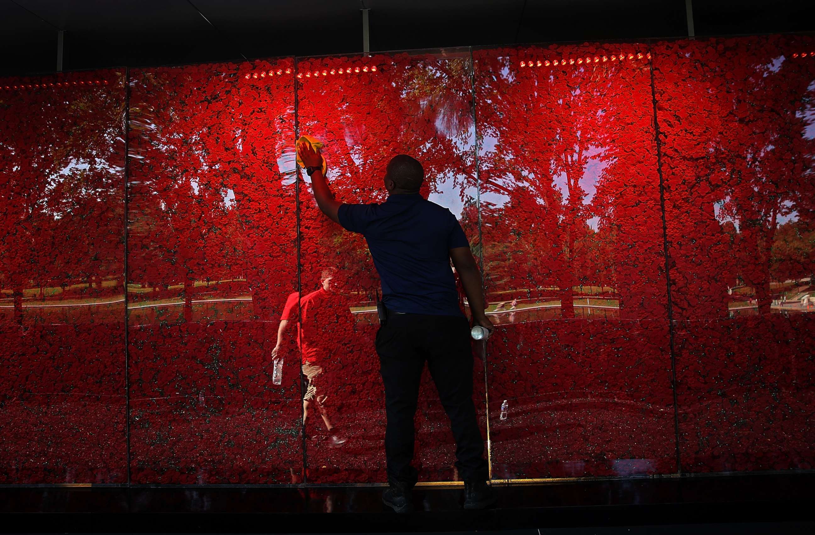 PHOTO: Romel Martin cleans glass panels while assisting with the installation of a temporary pop-up "Poppy Memorial" on the national mall near the Lincoln Memorial in advance of Memorial Day May 25, 2018 in Washington.