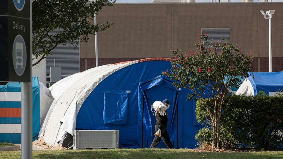 PHOTO: A construction crew works to set up tents that hospital officials plan to use with an overflow of COVID-19 patients outside of Lyndon B. Johnson Hospital, Aug. 9, 2021, in Houston.