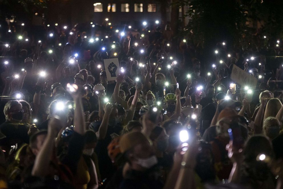 PHOTO: Protesters hold their cellphones in the air during a Black Lives Matter rally in front of the Multnomah County Justice Center, July 20, 2020 in Portland, Ore.