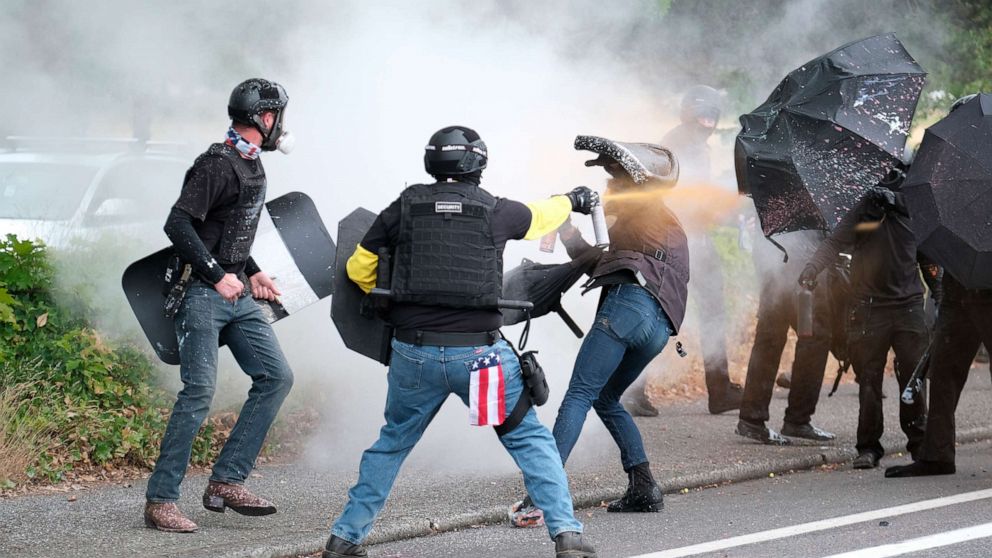 PHOTO: Members of the far-right group Proud Boys and anti-fascist protesters spray bear mace at each other during clashes between the politically opposed groups in Portland, Ore., Aug. 22, 2021. 