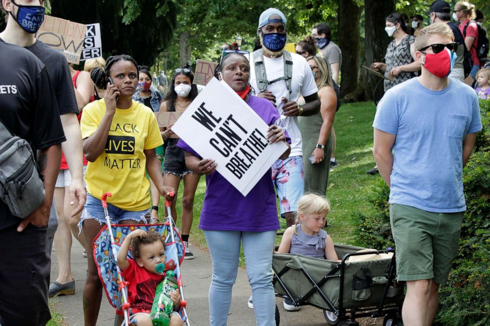 PHOTO: Katrina Hendricks, left, pushes a stroller holding her son, Melo, as her mother, Elaine Loving, walks alongside her at a Juneteenth rally and march through a historically Black neighborhood in Portland, Ore., June 19, 2020.