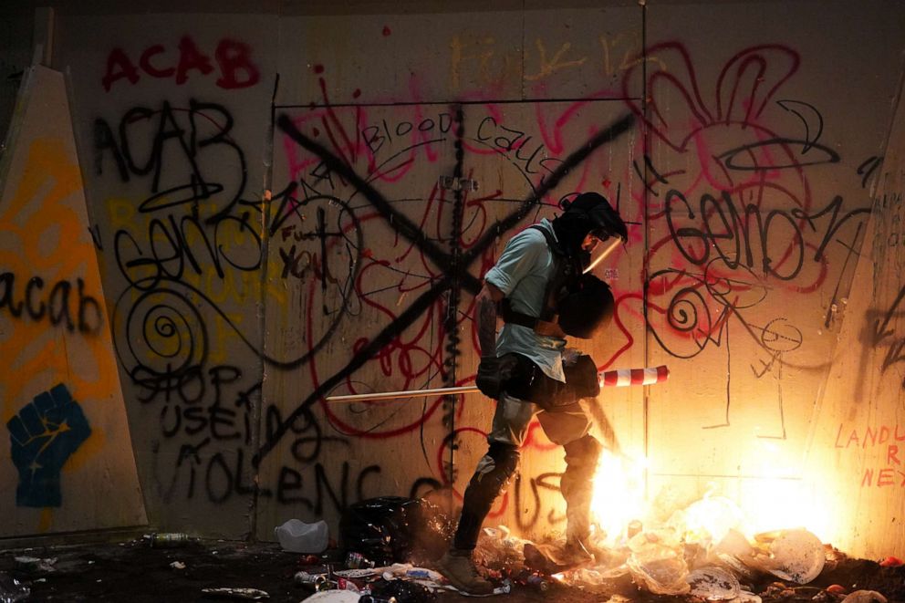 PHOTO: A protester attempts to stomp out a small fire during a protest at the Mark O. Hatfield U.S. Courthouse on July 21, 2020 in Portland, Ore.