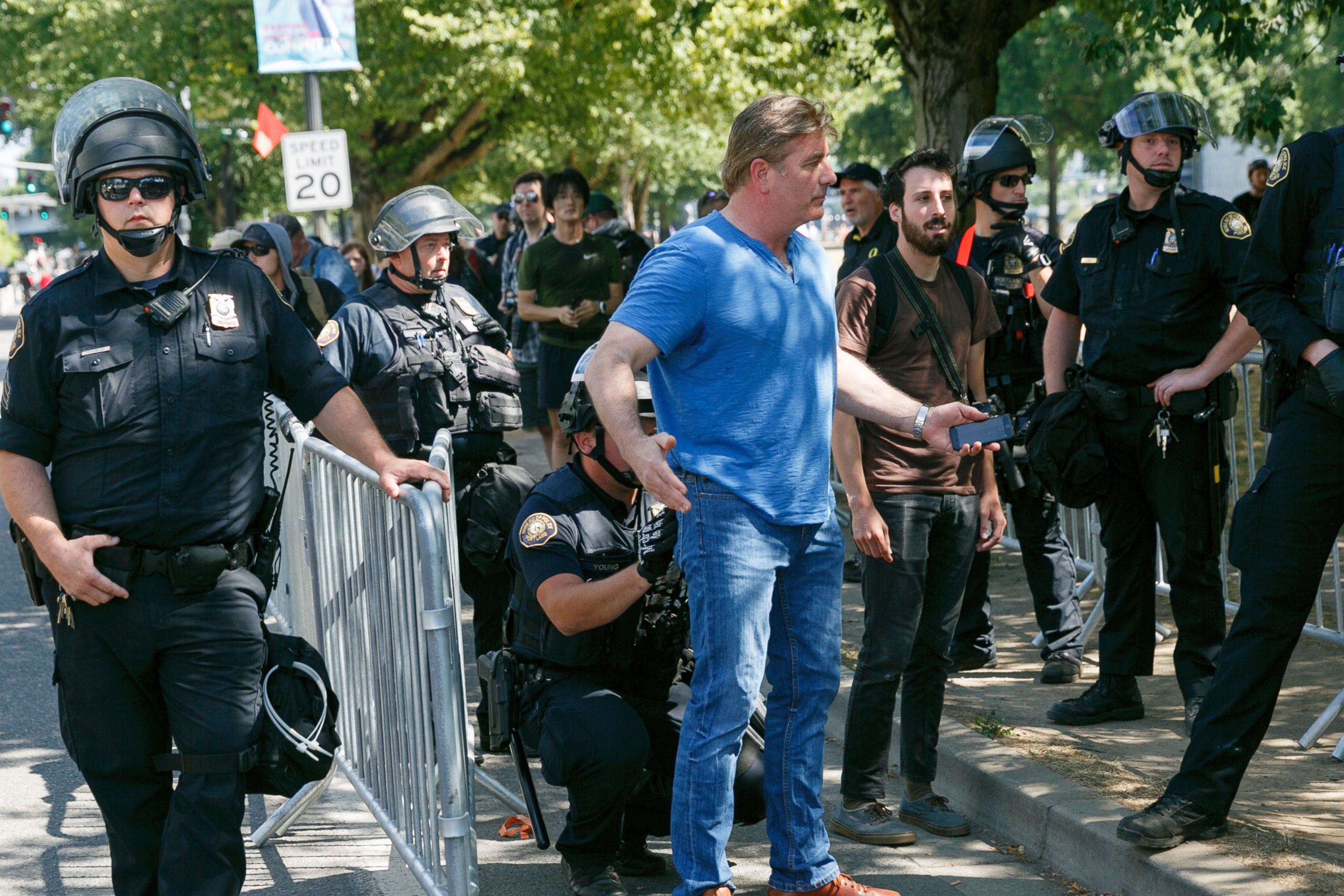 Police search a person before entering a rally in Portland, Ore., Saturday, Aug. 4, 2018.