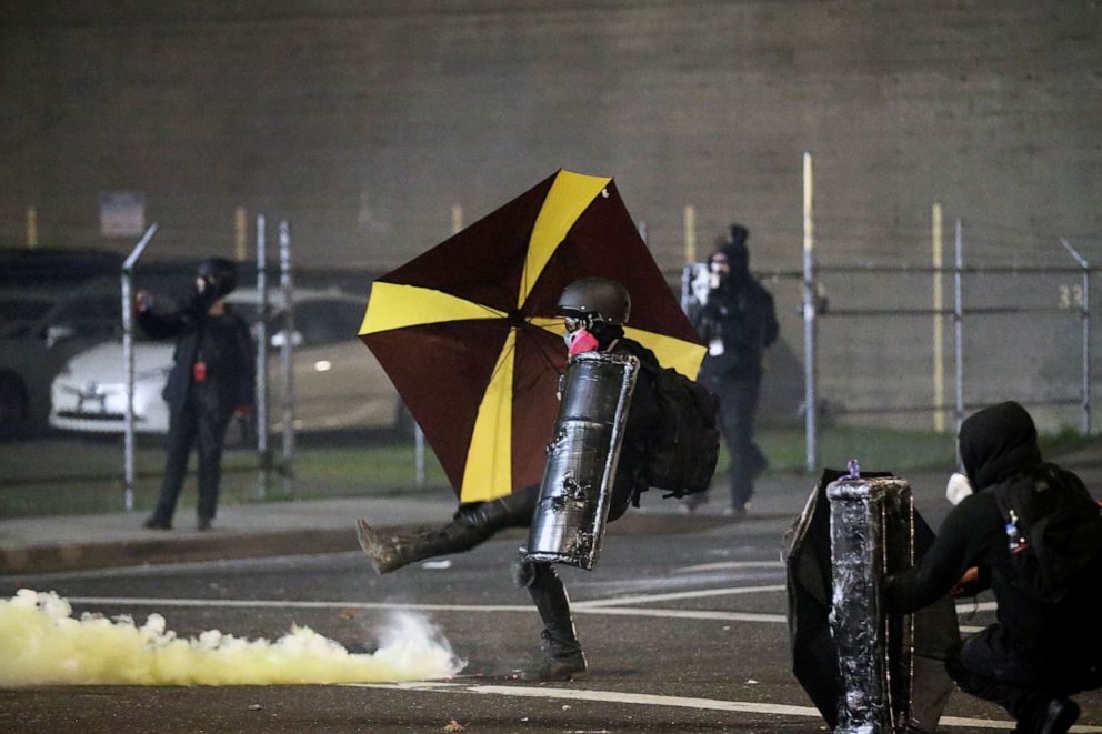 PHOTO: A demonstrator throws a tear gas canister back at law enforcement officers during a rally outside the field office of the U.S. Immigration and Customs Enforcement in Portland Oregon, on Jan. 20, 2021, after the inauguration of President Joe Biden.