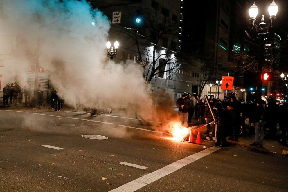 PHOTO: A small trash fire obscures the Justice Center after the full acquittal of Kyle Rittenhouse in his Wisconsin fatal shootings trial, in Portland, Ore., Nov. 19, 2021.