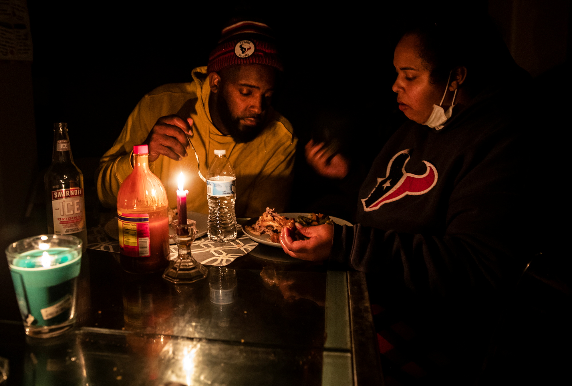 PHOTO: Howard and Nena Mamu eat dinner at their home by candle light after power companies performed rotating outages in Glenwood neighborhood in Hutto, Texas Feb. 16, 2021.