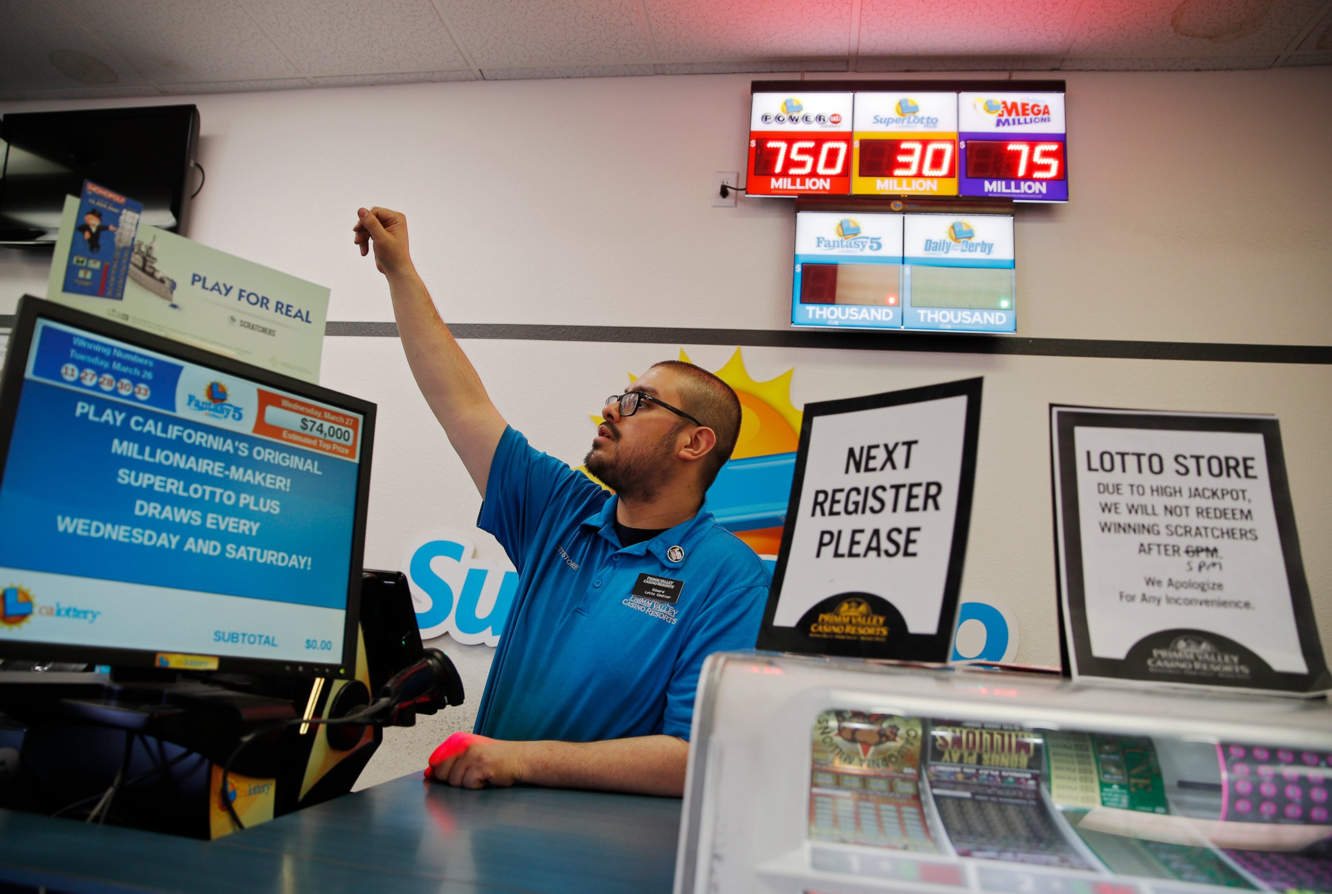 PHOTO: Cashier Edward Kelliher sells lottery tickets at the Lotto Store at Primm just inside the California border Wednesday, March 27, 2019, near Primm, Nev. The Powerball jackpot soared to a massive $750 million Wednesday.