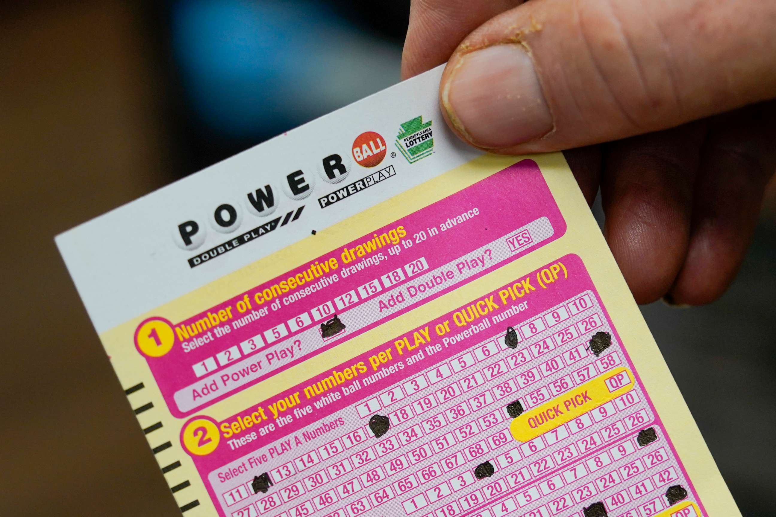 PHOTO: A customer shows his scan card for his personal selection numbers for a ticket for a Monday Powerball drawing on Nov. 7, 2022, at a convenience store in Renfrew, Pa.