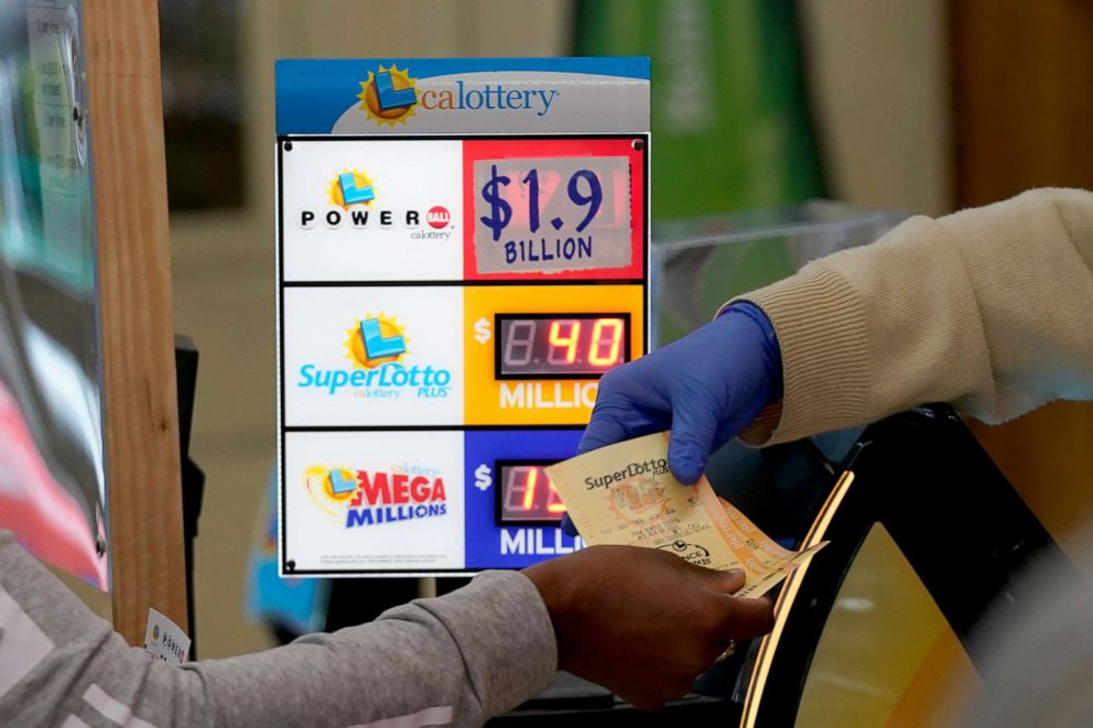 PHOTO: A customer is handed Powerball tickets purchased at Lichine's Liquor & Deli in Sacramento, Calif., Monday, Nov. 7, 2022.