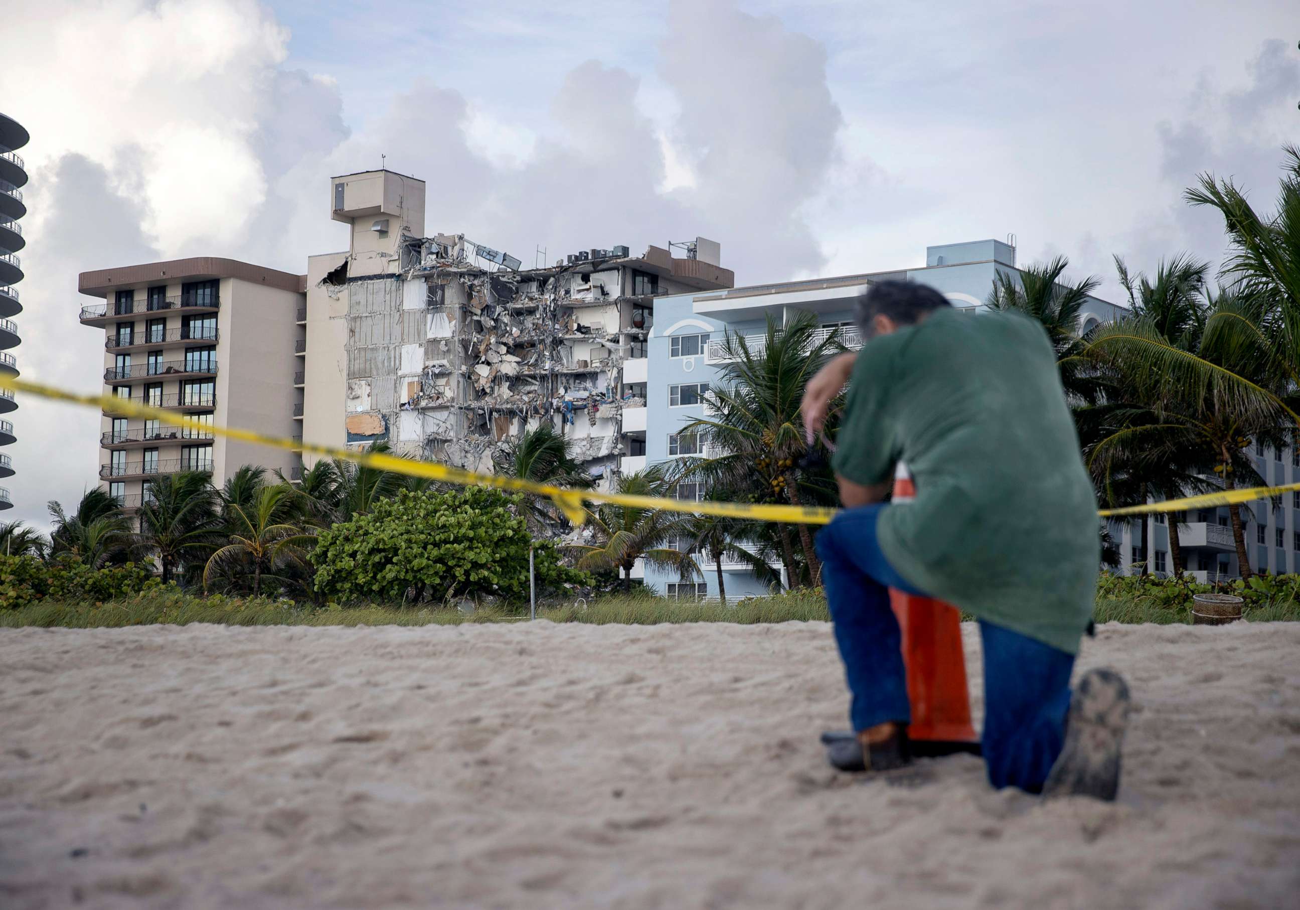 PHOTO: A man prays near where search and rescue operations continue at the site of the partially collapsed 12-story Champlain Towers South condo building, June 25, 2021, in Surfside, Fla., near Miami Beach.