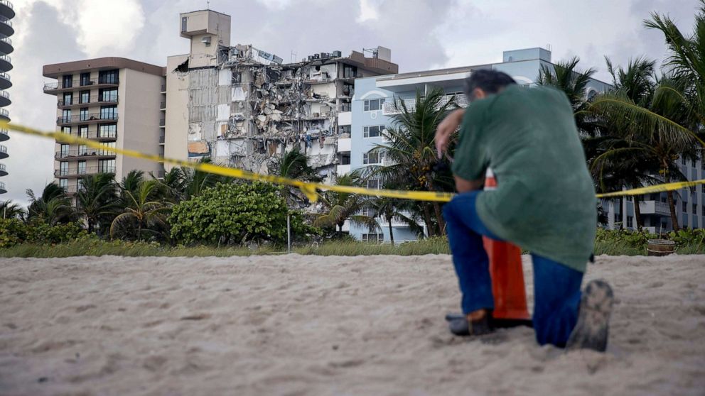 PHOTO: A man prays near where search and rescue operations continue at the site of the partially collapsed 12-story Champlain Towers South condo building, June 25, 2021, in Surfside, Fla., near Miami Beach.