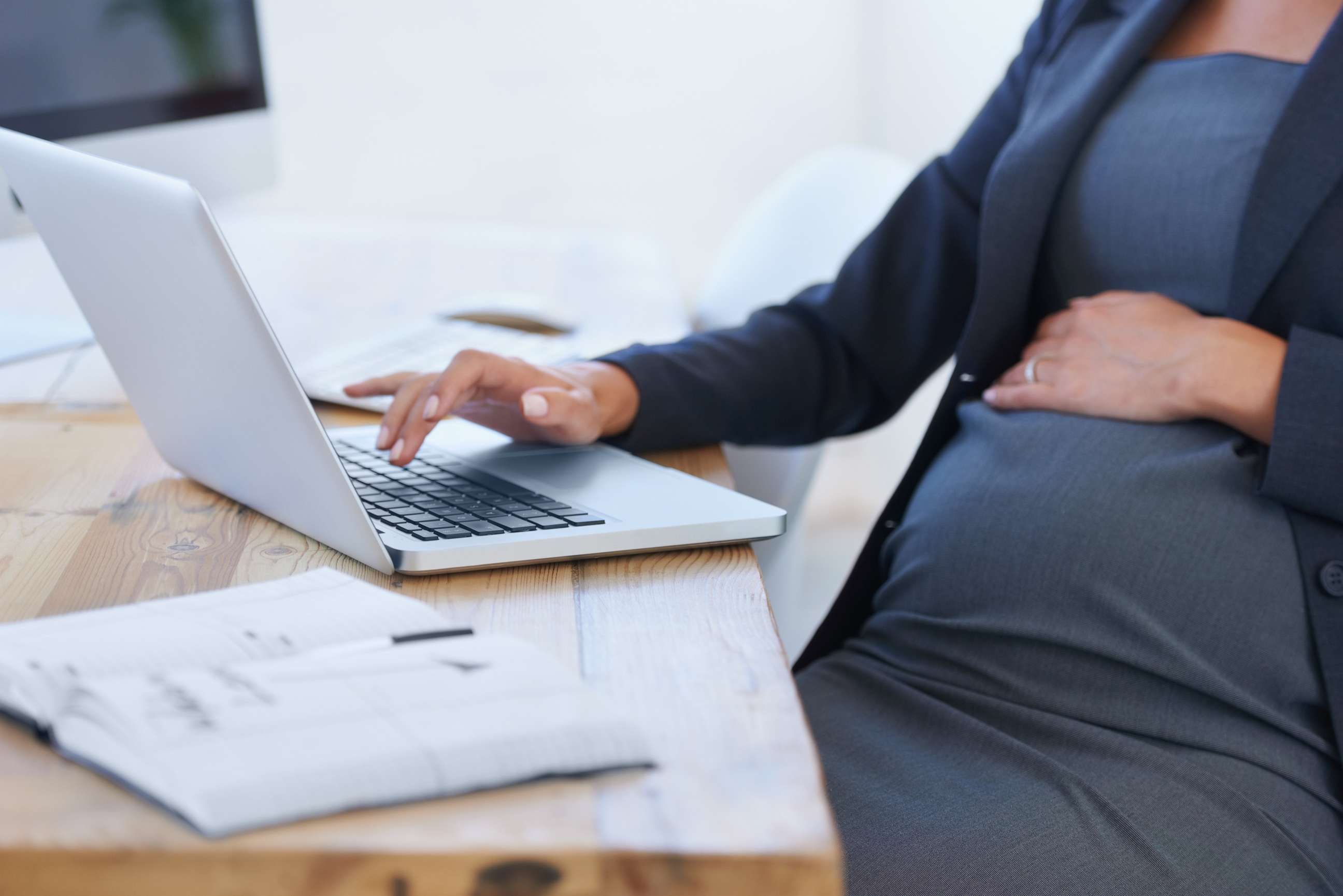 PHOTO: A pregnant woman works on her laptop in an office.