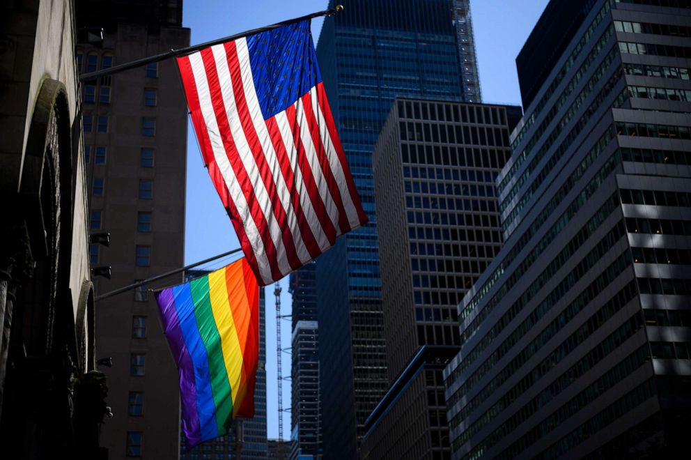 PHOTO: A rainbow flag and a U.S. flag are seen in front of the St Bartholomew's Church on June 11, 2019 in New York.