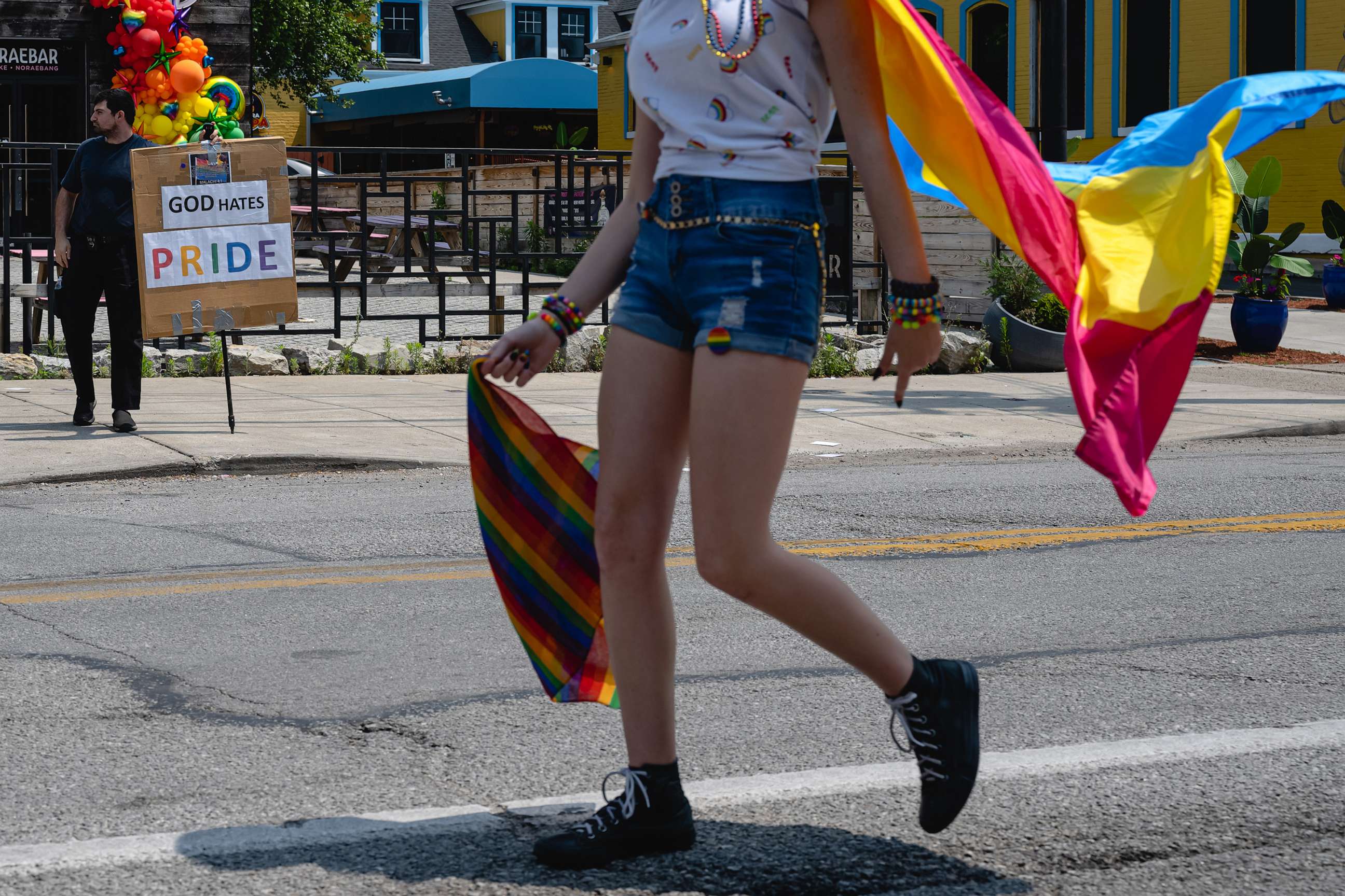 PHOTO: A protester holds a sign reading "GOD HATES PRIDE" as parade participants pass during the Kentuckiana Pride Parade, June 17, 2023, in Louisville, Ky.