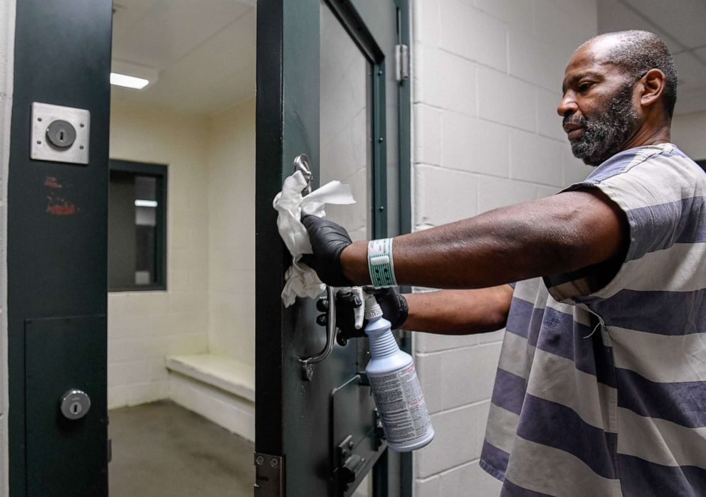 PHOTO: Mark Garrett cleans a holding cell at the Vanderburgh County jail, March 13, 2020.