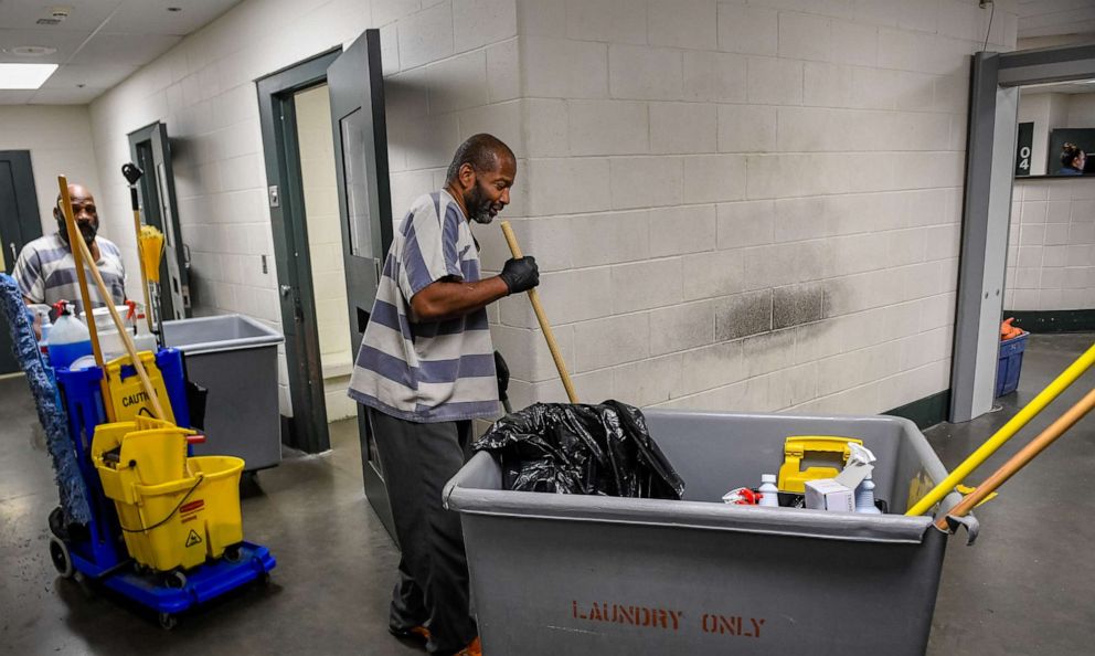 PHOTO: Inmates John Moore, left, and Mark Garrett one of two cleaning crews at the Vanderburgh County jail clean holding cells, March 13, 2020.
