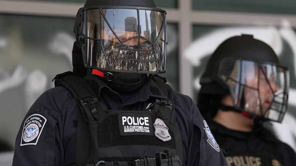 PHOTO: Customs and Border Protection police stand outside the Federal Building, covered in graffiti following protests triggered by immigration raids, in Los Angeles, June 9, 2025.