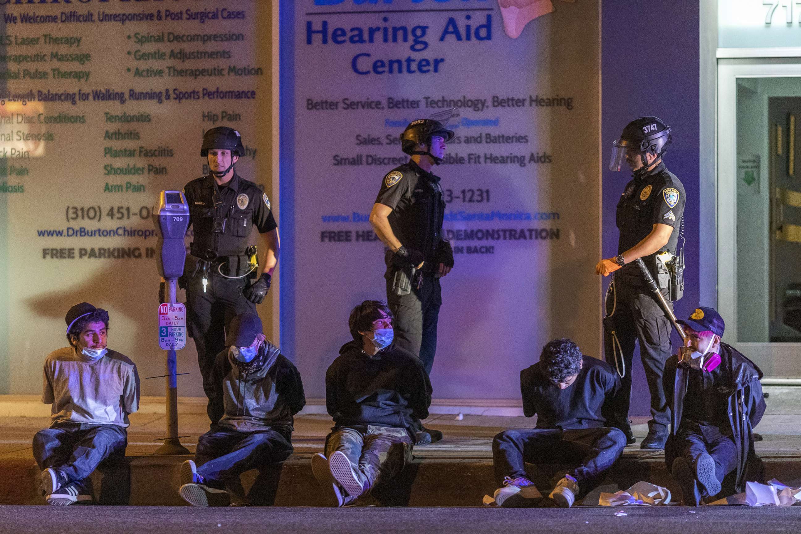 PHOTO: People sit in handcuffs under arrest during an emergency curfew during demonstrations following the death of George Floyd, May 31, 2020, in Santa Monica, California.