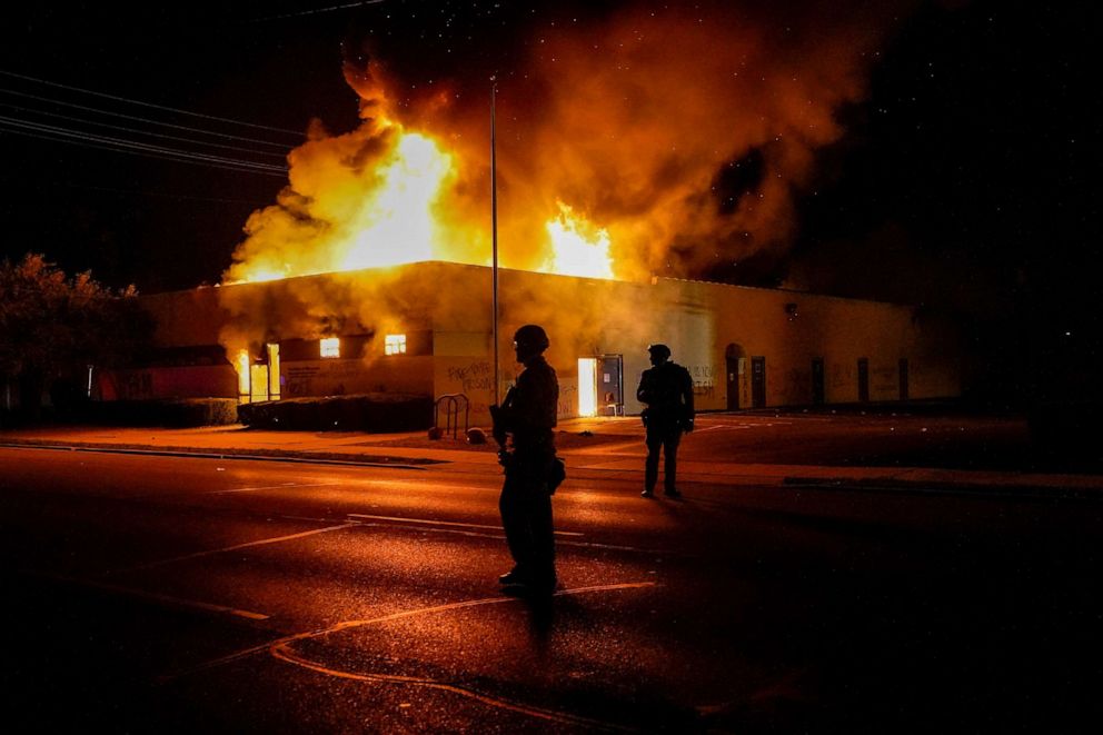 PHOTO: Police stand near a department of corrections building that was on fire during protests, Monday, Aug. 24, 2020, in Kenosha, Wis., sparked by the shooting of Jacob Blake by a Kenosha Police officer a day earlier.