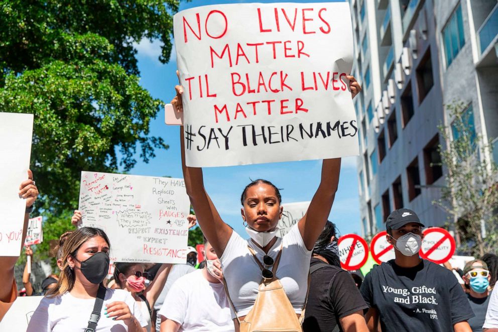 PHOTO: Demonstrators hold signs and chant as they protest police brutality in at Bayfront Park in downtown Miami, May 30, 2020 in response to the recent death of George Floyd.