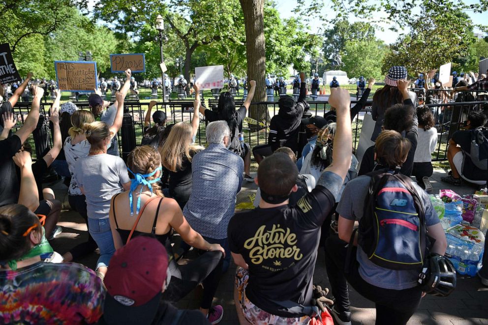 PHOTO: Protestors take a knee and raise their fists in Lafayette Square near the White House, June 1, 2020, during protests against police brutality.