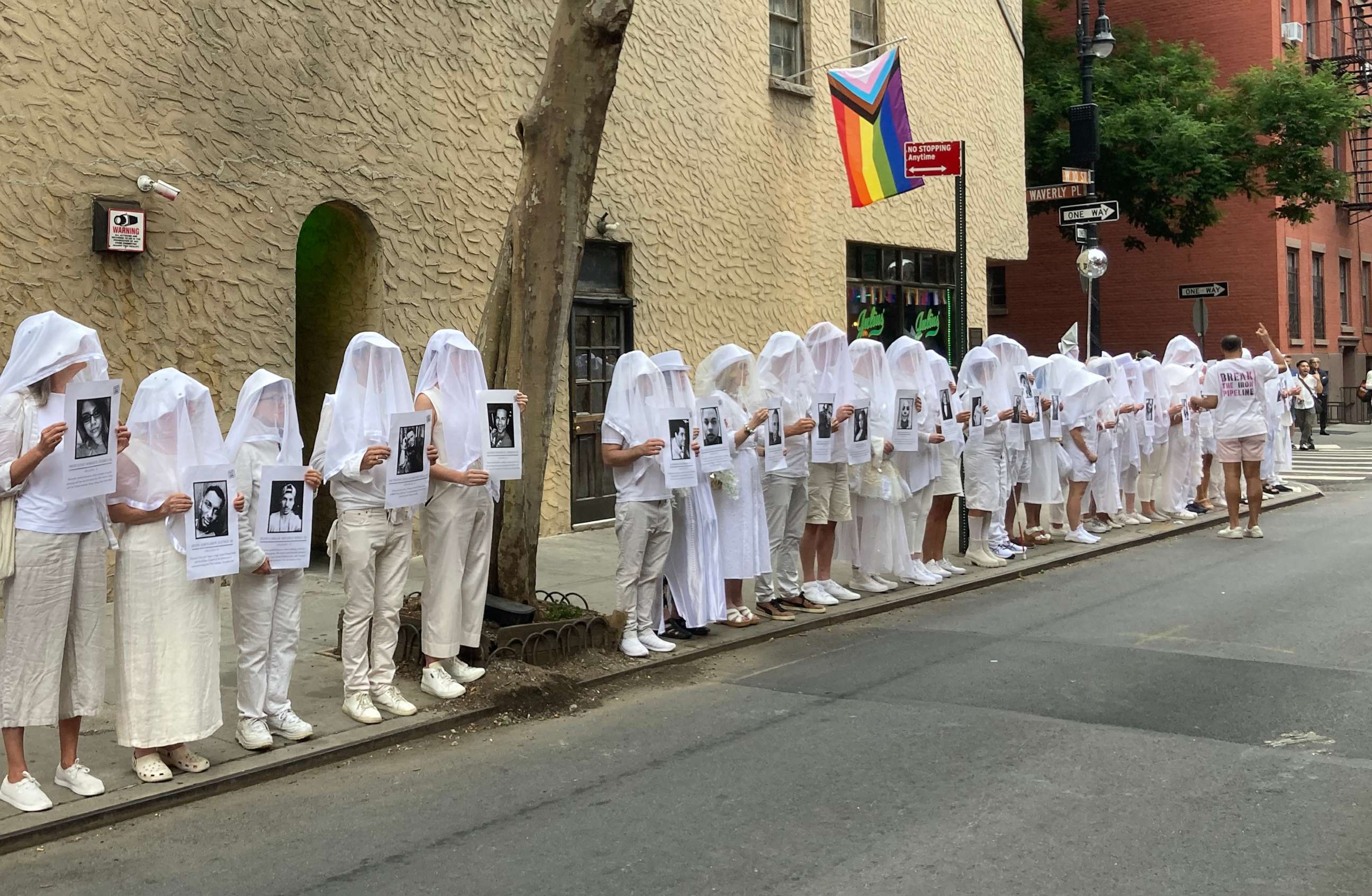 PHOTO: Vigil participants, holding placards for the 49 victims of the Pulse nightclub shooting, stand silently outside the historic gay bar Julius’ as they process through New York City’s Greenwich Village, June 12, 2023.