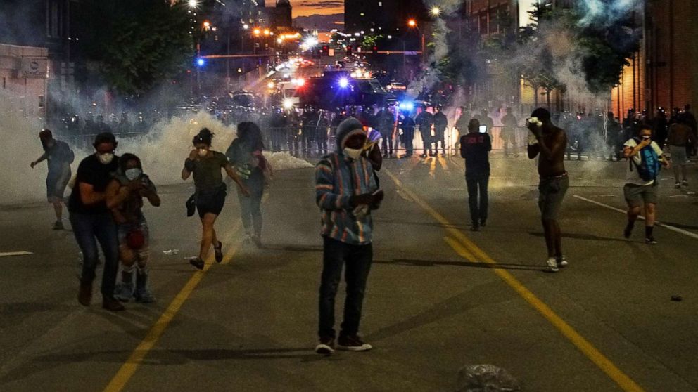 PHOTO: A man reads a Bible as protestors run from tear gas during a protest against the death in Minneapolis police custody of African-American man George Floyd, in St Louis, Mo., June 1, 2020.