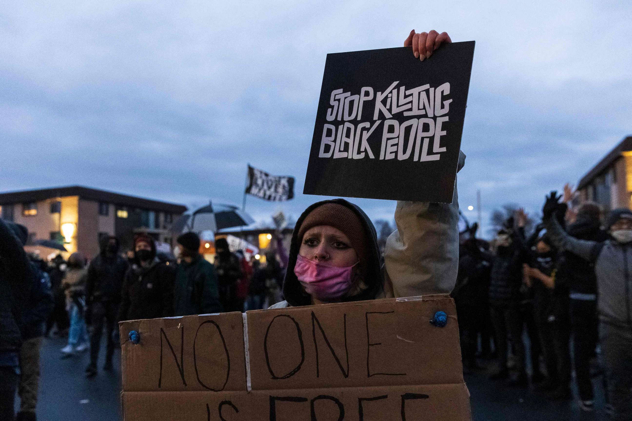 PHOTO: A demonstrator holds a sign reading "Stop Killing Black People" as she stands outside the Brooklyn Center Police Department in Brooklyn Center, Minnesota, on April 14, 2021, amid a fourth day of protests over the fatal shooting of Daunte Wright.