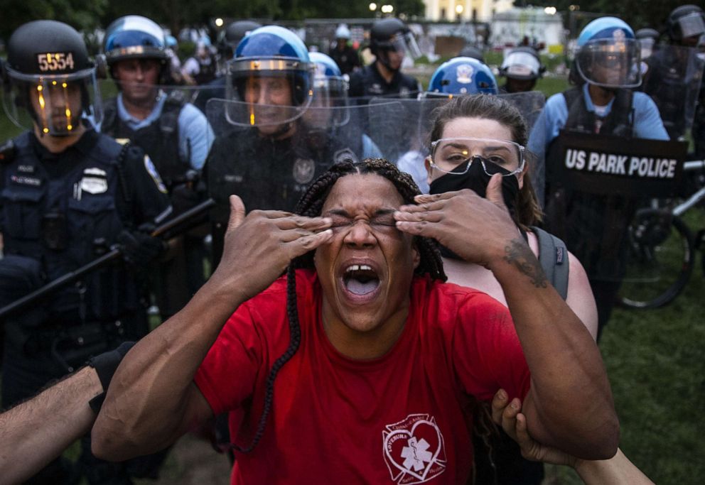 PHOTO: A woman reacts to being hit with pepper spray as protesters clash with police after they attempted to pull down the statue of former U.S. President Andrew Jackson in Lafayette Square near the White House in Washington, D.C., on June 22, 2020.