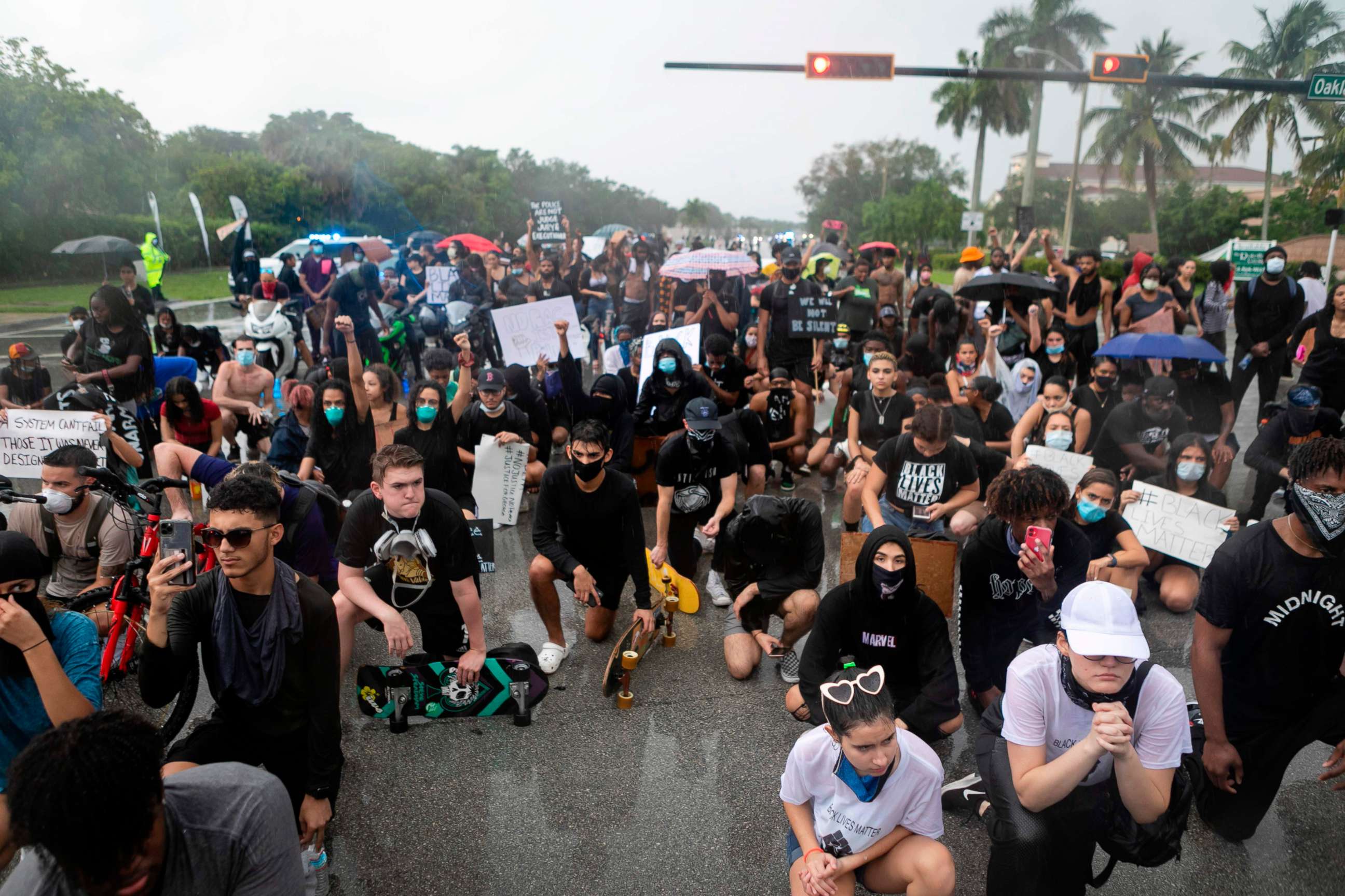 PHOTO: Demonstrators kneel under heavy rain during a protest against police brutality and the recent death of George Floyd in Sunrise, Florida on June 02, 2020. 