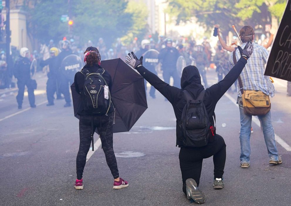 PHOTO: Demonstrators kneel in front of a line of police officers during a protest for the death of George Floyd, Monday, June 1, 2020, near the White House in Washington.