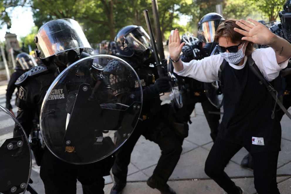 PHOTO: A demonstrator raises the hands next to U.S. Secret Service uniformed division officers during a rally near the White House against the death in Minneapolis police custody of George Floyd, in Washington, D.C., June 1, 2020.