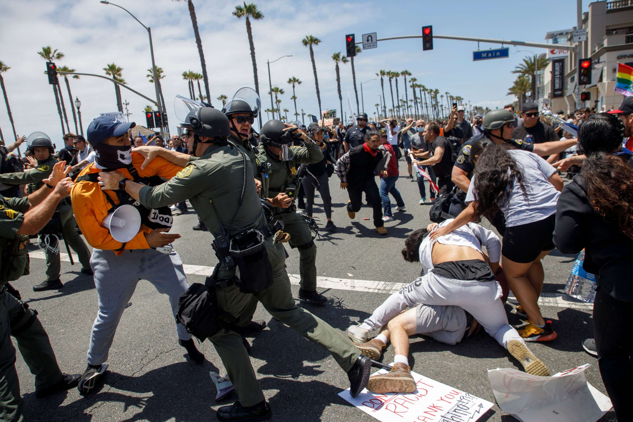 PHOTO: Black Lives Matter protesters fight with supporters of US President Donald Trump as police try to break up the clashes during a demonstration due to the police killing of George Floyd in Huntington Beach, California, June 6, 2020.