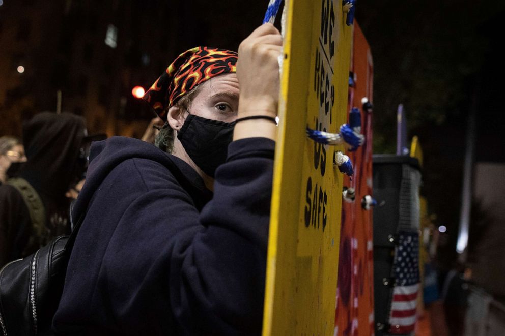 PHOTO: A protester holds a homemade riot shield during a protest in front of the Oakland Police Department Station, July 25, 2020, in Oakland, Calif.