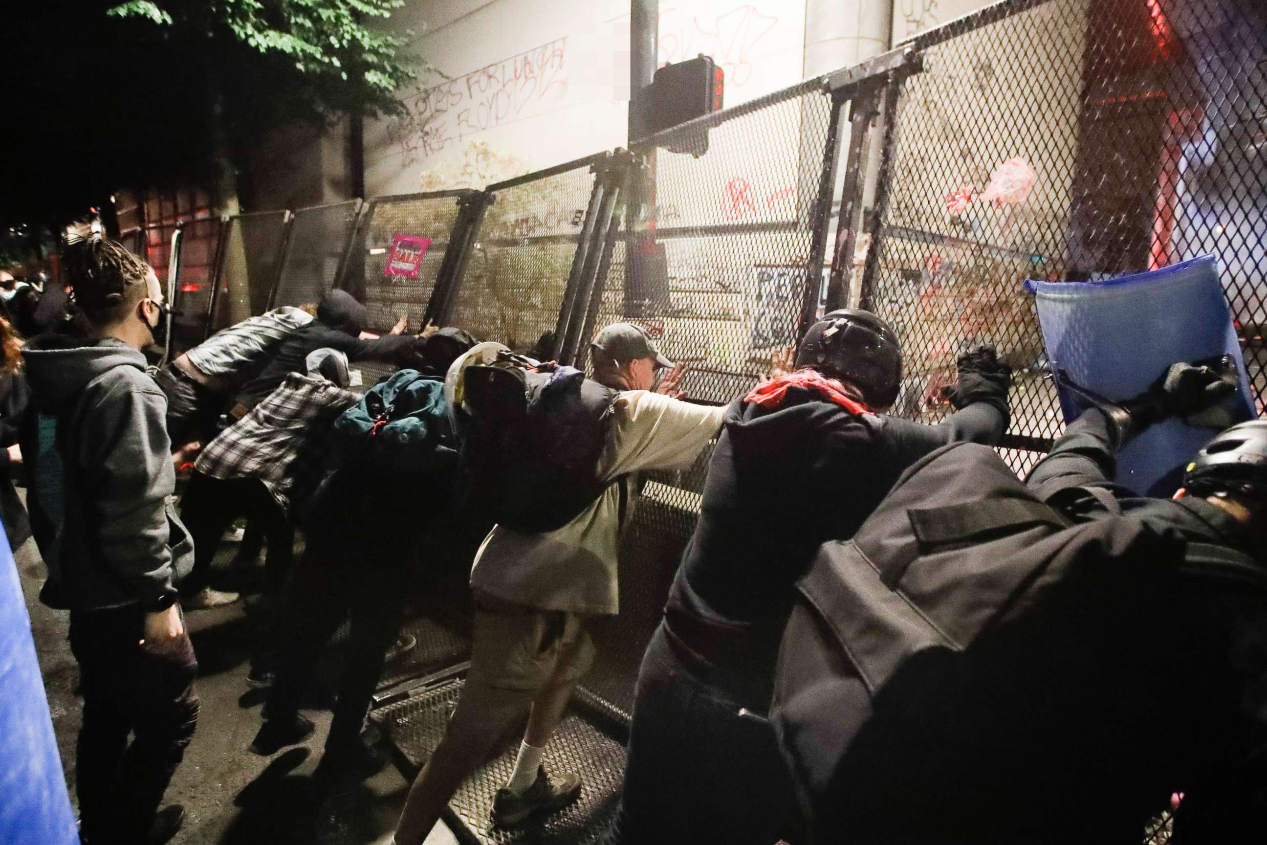 PHOTO: Demonstrators try to topple a steel fence during a Black Lives Matter protest at the Mark O. Hatfield United States Courthouse, July 25, 2020, in Portland, Ore.